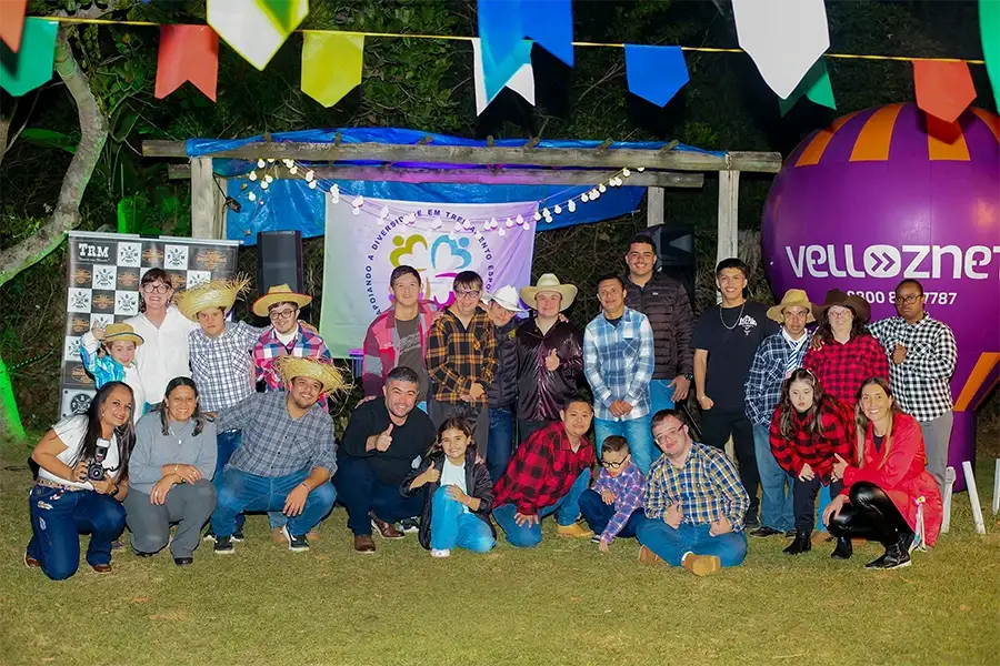 Participantes, familiares e equipe da ADAPTE reunidos em uma festa comunitária